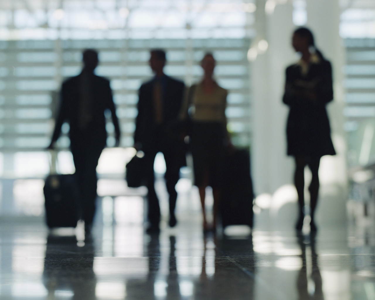 Businesspeople Walking Through Airport with Luggage